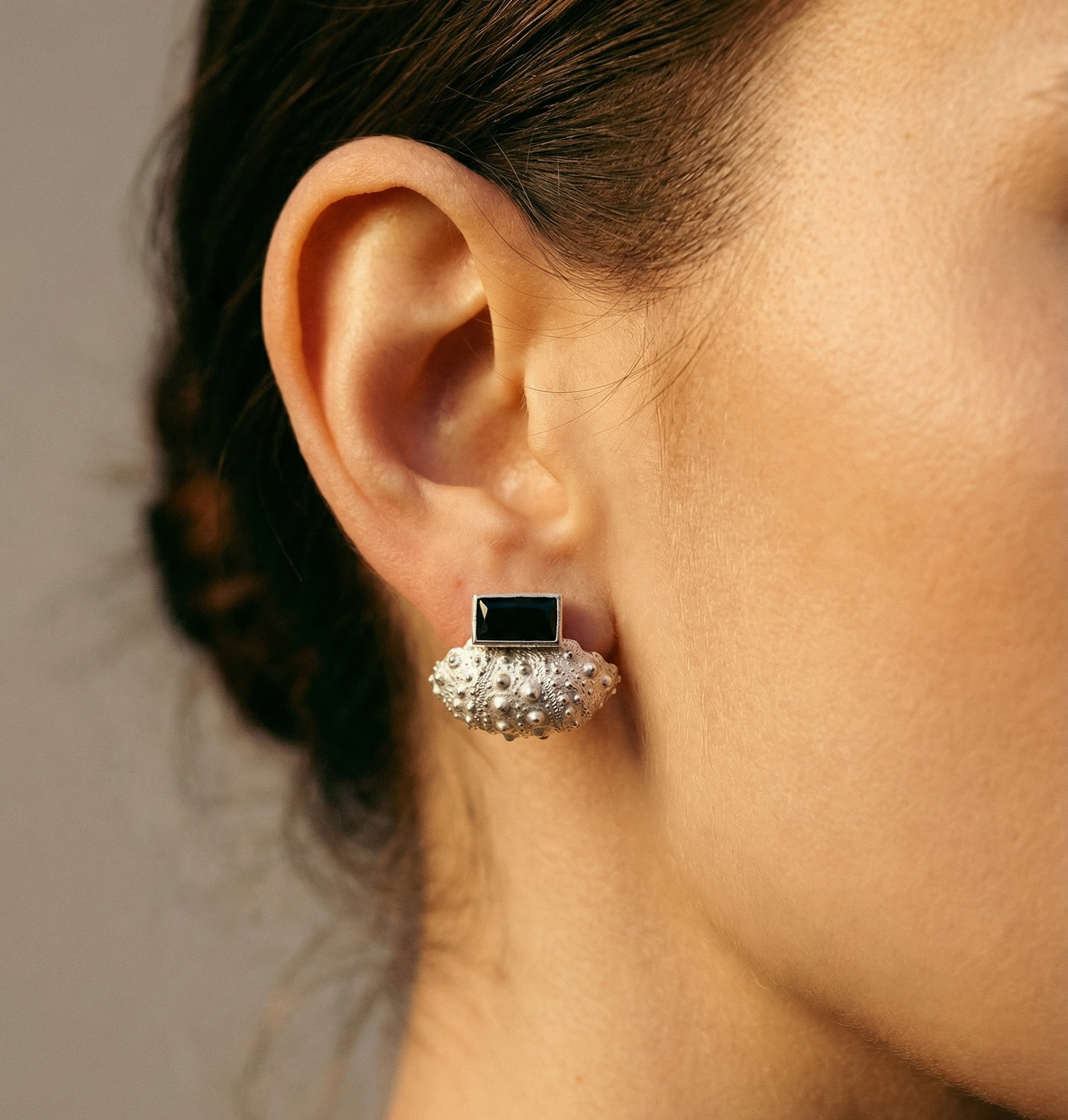Woman wearing Ceto sea urchin ear jacket set with black spinel post in polished sterling silver